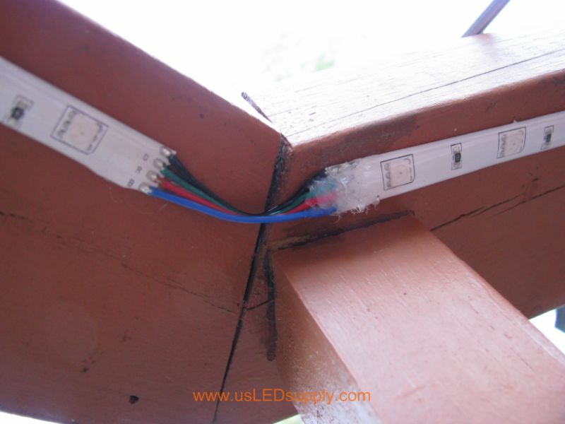Attach flexible LED strip to underside of deck railing, by peeling off the self stick backing.  Then, go over the edges with waterproof silicon.