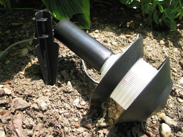 Start putting the light stake into the ground.