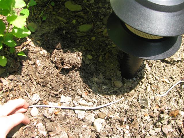 Bury the control cable with your hands or a shovel if the ground is hard.